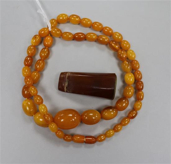 A single strand amber bead necklace, 28grms and an amber cigar holder.